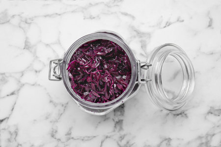 Tasty red cabbage sauerkraut on white marble table, top view