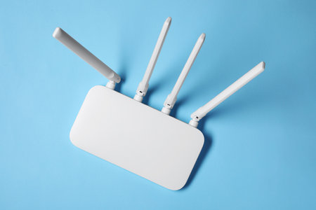New white WiFi router on light blue background, top viewの写真素材