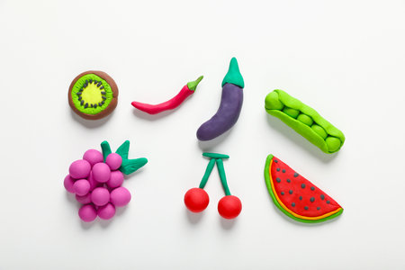 Different colorful fruits and vegetables made from plasticine on white background, top viewの写真素材