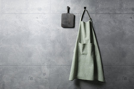 Clean kitchen apron with pattern and board on gray tiled wall. Space for textの写真素材