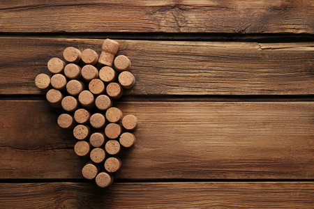 Grape made of wine bottle corks on wooden table, top view. Space for textの写真素材