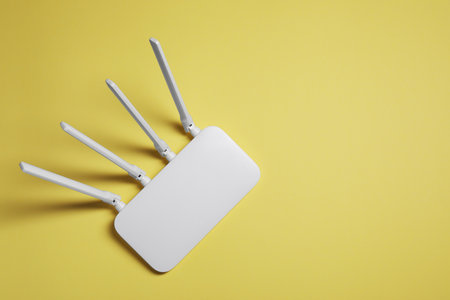 New white router on yellow background, top view. Space for text