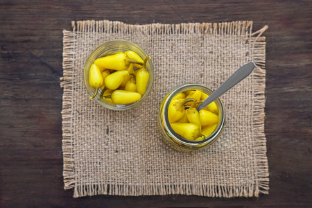 Pickled yellow jalapeno peppers on wooden table, top viewの写真素材