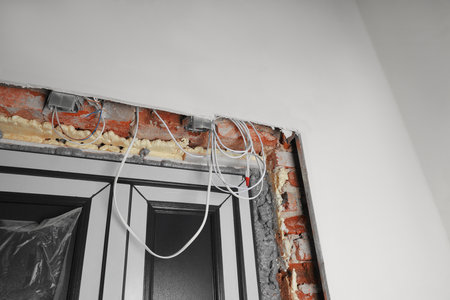 Cables in wall near doors indoors. Installation of electrical wiringの写真素材