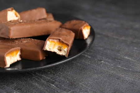 Plate with delicious chocolate bars on black table, closeup. Space for textの写真素材