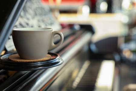 Cup with cork coaster on grand piano in cafe, closeup. Space for textの写真素材