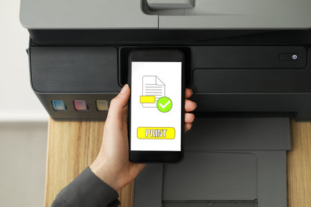 Woman using printer management application on smartphone indoors, closeup. Image on device screen.