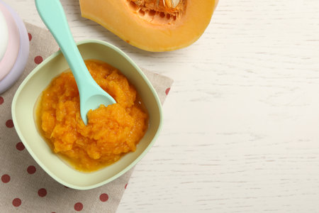 baby food. Tasty pumpkin puree on white wooden table, flat lay. Space for textの写真素材