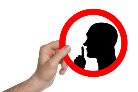 Quiet please. Man holding sign with shush gesture image on white background, closeupの写真素材