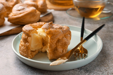 Delicious profiterole filled with cream on gray table, closeupの写真素材