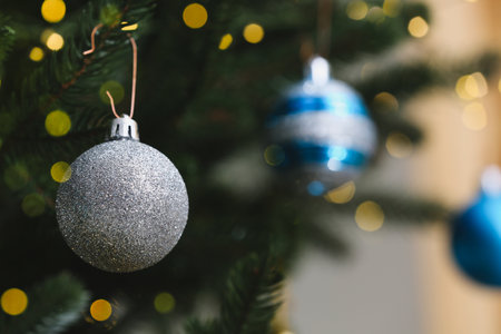 Beautiful Christmas ball hanging on fir tree branch, closeup. Space for textの写真素材