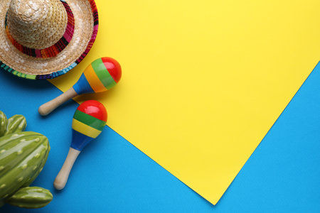 Maracas, toy cactus and sombrero hat on colorful background, flat lay with space for text. musical...