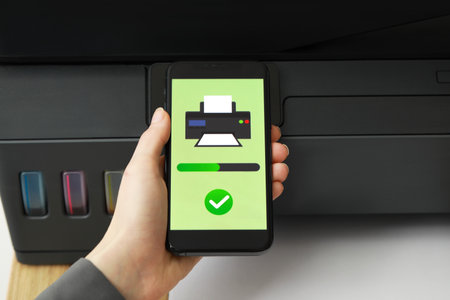 Woman using printer management application on smartphone at table, closeup. Image on device screen.