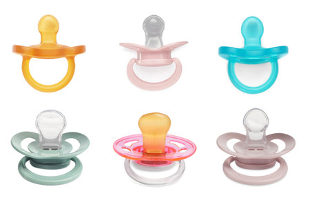Collage of baby pacifiers in different colors on white backgroundの写真素材