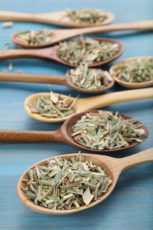 Spoons with aromatic dried lemongrass on light blue wooden tableの写真素材