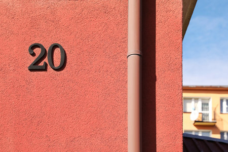 Number 20 on beautiful pink house outdoors. Space for textの写真素材
