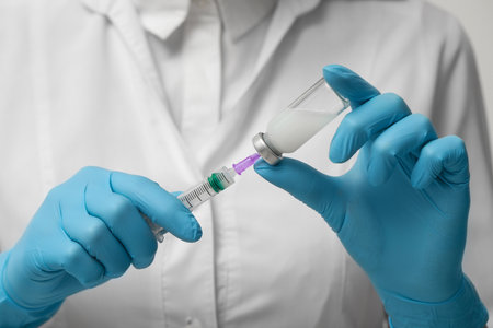 Doctor filling syringe with hepatitis vaccine from glass vial, closeupの写真素材