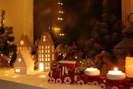 House shaped lanterns and Christmas decor on windowsill indoorsの写真素材