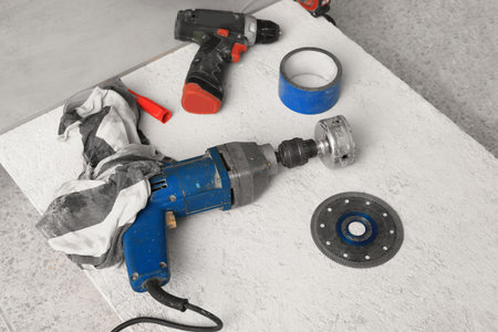 Buffing attachment drill and other equipment on chipboard indoors. Tiles installation process