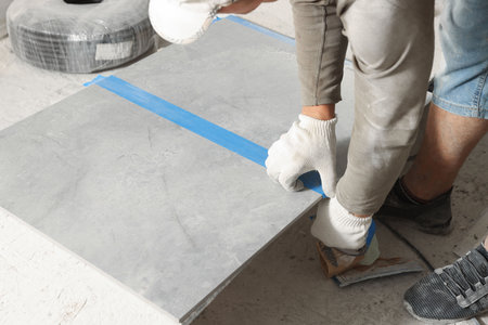 Worker measuring tiles for installation, closeup viewの写真素材