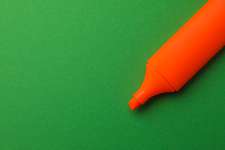 Bright orange marker on green background, top view. Space for textの写真素材
