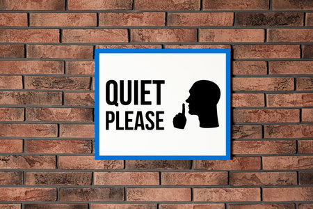 Quiet Please sign with shush gesture image on red brick wallの写真素材