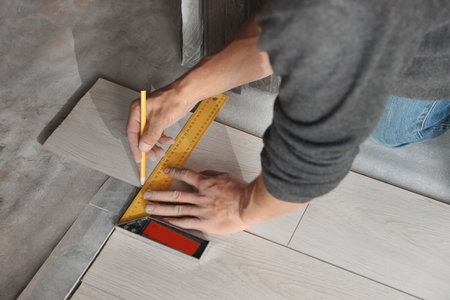 Worker installing new laminate flooring in room, closeupの写真素材