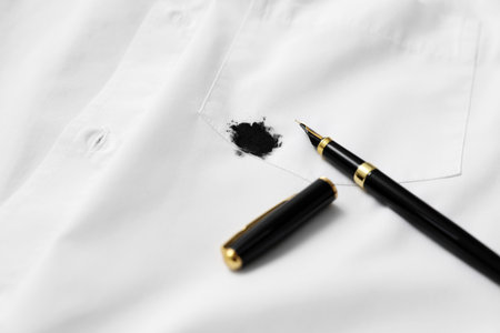 Pen and stained black ink on white shirt, closeup. Space for text