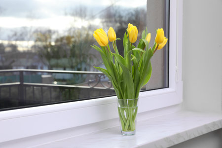 Wonderful tulips on window sill indoors, space for text. spring atmosphere