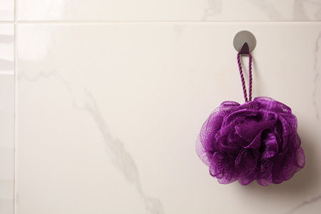 Purple shower puff hanging in bathroom, space for textの写真素材