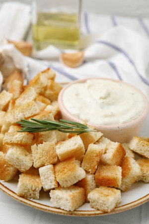 Delicious crispy croutons with rosemary and sauce on plate, closeupの写真素材
