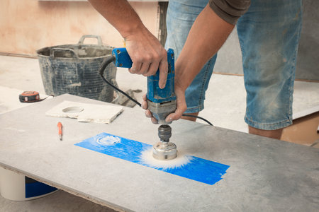 Worker making socket hole in tile indoors, closeupの写真素材