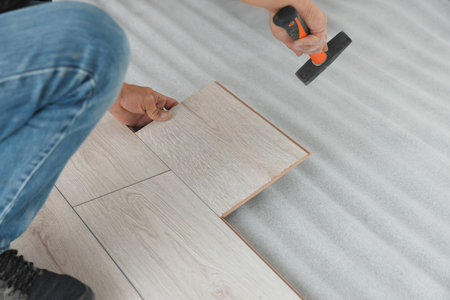 Worker installing new laminate flooring in room, closeupの写真素材
