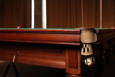 Stylish billiard table with white balls in pocket indoors