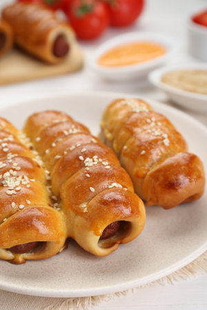 Delicious sausage rolls and ingredients on white wooden table, closeupの写真素材