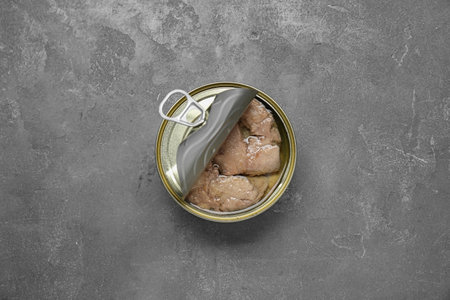 Open tin can of tasty cod liver on gray table, top viewの写真素材