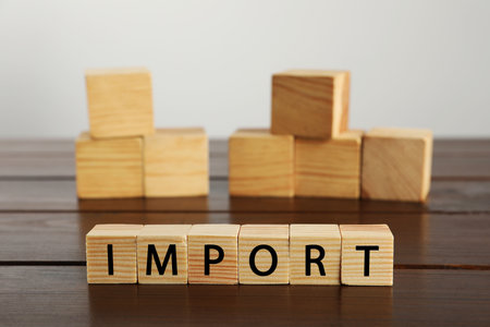 Word Import made of cubes on wooden tableの写真素材