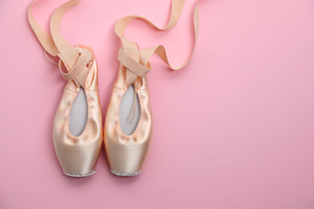 Ballet shoes. Elegant pointes on pink background, flat lay. Space for textの写真素材