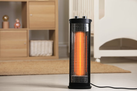 Modern infrared heater on floor in cozy room. Space for text