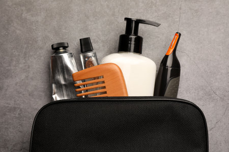 Preparation for spa. Compact toiletry bag with different cosmetic products on gray textured background, top viewの写真素材