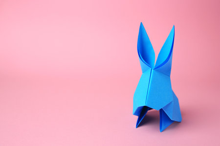 origami art. Paper rabbit on pink background, space for textの写真素材
