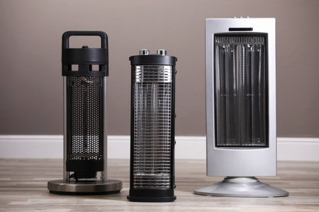 Different modern infrared heaters on floor indoors