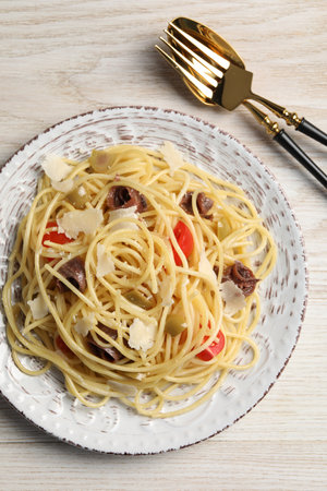 Delicious pasta with anchovies, tomatoes and parmesan cheese served on white wooden table, flat layの写真素材