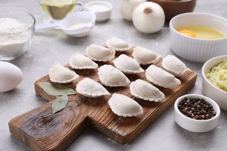 Raw dumplings (varenyky) and ingredients on gray tableの写真素材