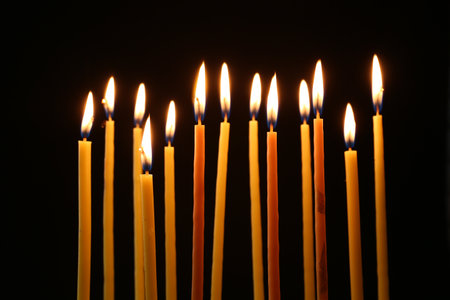 Many burning church candles on dark backgroundの写真素材