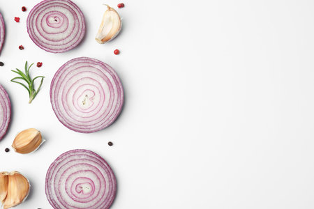 Fresh red onions, garlic, rosemary and spices on white background, flat lay. Space for textの写真素材