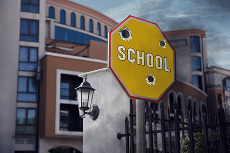 School sign damaged with shooting near buildingの写真素材
