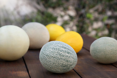 Tasty ripe melons on wooden table outdoorsの写真素材