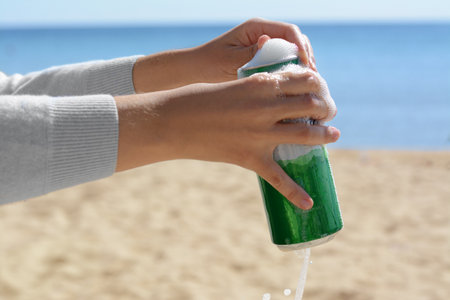 Woman opening can with sparkling drink at beach, closeupの写真素材