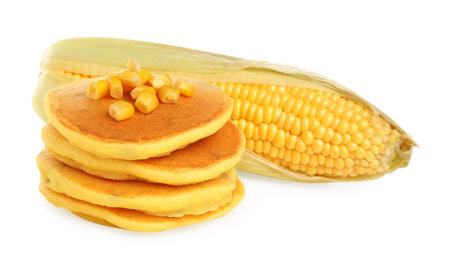 Stack of tasty corn pancakes with sweet kernels and cob isolated on whiteの写真素材